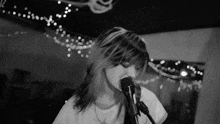 a woman singing into a microphone in a black and white photo