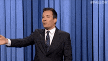 a man in a suit and tie is standing on a stage .