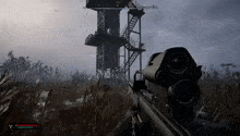 a person is holding a rifle in a video game in front of a tower .