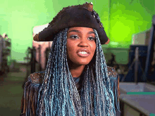 a woman with blue braids is wearing a hat