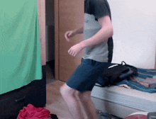 a man is dancing in a room with a green screen