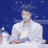 a man is sitting at a table with a bottle of sprite in front of him .