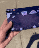 a person is holding a nintendo 3ds with stickers on the back