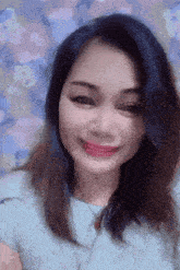 a woman wearing a blue shirt and red lipstick is smiling