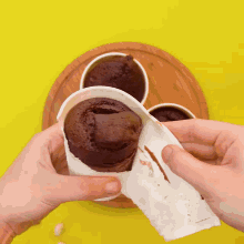 a person is holding a chocolate cake in their hands