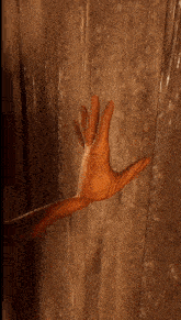 a wooden hand is reaching out towards a wall