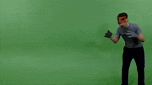a man wearing a fox mask and gloves is dancing on a green screen .