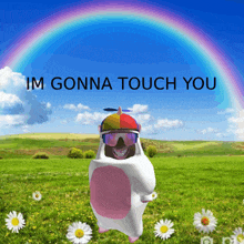 a hamster in a unicorn costume is standing in a field with a rainbow in the background