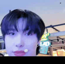 a close up of a person 's face with a lad sign behind them