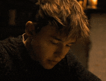 a close up of a young man 's face with a sweater on