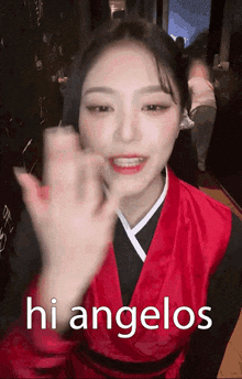 a woman in a red kimono is waving her hand and says hi angelos