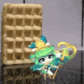 a little girl with green hair is standing next to a large waffle
