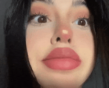 a close up of a woman 's face with red lips and a nose ring .