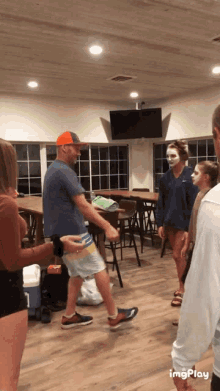 a group of people are standing in a room and one of them has a face mask on her face