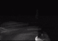 a blurry picture of a person holding a knife in their hand in the dark .