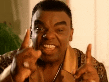 a man in a leopard print shirt is pointing his finger at the camera
