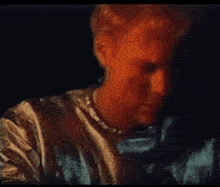 a blurry picture of a man with red hair and a pearl necklace