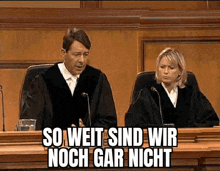 a man and a woman are sitting in a courtroom with a caption that says so weit sind wir noch gar nicht .