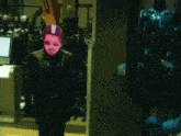 a man with a pink mask on his face is standing in front of a computer