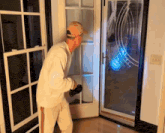 a man holding a flashlight stands in front of a door