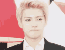 a man in a suit and white shirt is making a face