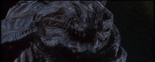 a close up of a monster 's face with a black background