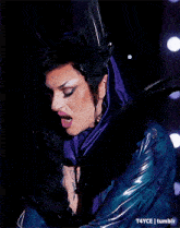 a close up of a woman wearing a purple scarf and a blue jacket