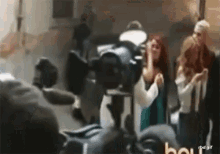 a group of people are standing in front of a camera and a sign that says rbd.gif