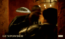 a man is standing in a room with the word gunpowder on the bottom