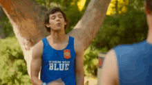 a man wearing a blue tank top with the word blue on it