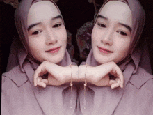 a woman wearing a hijab and earrings looks at her reflection in the mirror