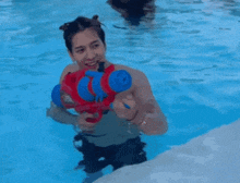 a man in a swimming pool holding a water gun