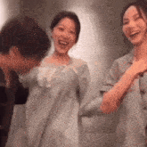 a man and two women are standing next to each other laughing .