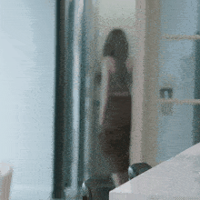 a blurred image of a woman standing in a hallway