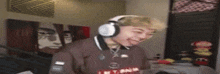 a young man wearing headphones is making a funny face in a room .