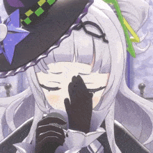 a girl in a witch hat is covering her face with her hands