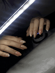 a close up of a woman 's nails with a light shining on them