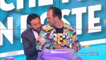 two men are hugging each other in front of a sign that says surprise