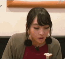 a woman is sitting at a table with a fork in her hand and eating food .