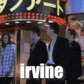 a group of people standing in front of a sign that says " irvine "