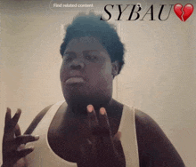 a man in a white tank top is standing in front of a screen that says " sybau "