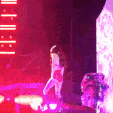 a woman is standing on a stage in front of a neon sign that says ' i 'm sorry '