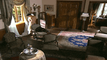 a living room with a table and chairs and a rug on the floor