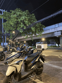 a honda scooter is parked on the side of the road at night