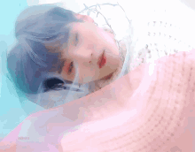 a close up of a person laying on a bed with a pink cloth covering their face .
