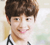 a young man with a stethoscope around his neck smiles for the camera with a mbc logo behind him