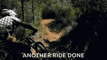 a man is riding a mountain bike down a dirt road .