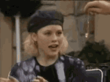 a woman wearing a black beret and a purple jacket is sitting at a table .