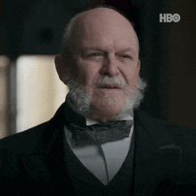 an older man with a beard and bow tie is on a hbo screen