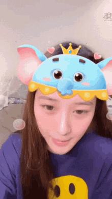 a woman wearing a blue hat with elephant ears and a crown on top